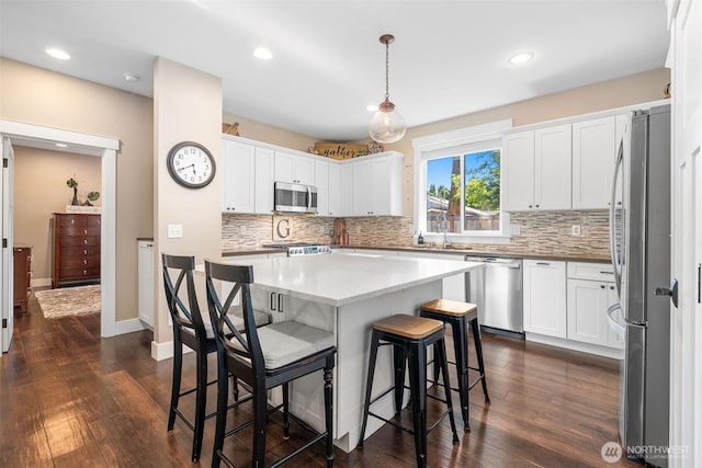 7235 20th Ave SE Unit A & B, Lacey, WA 98503 - kitchen with appliances with stainless steel finishes, decorative backsplash, a kitchen breakfast bar, white cabinets, and recessed lighting