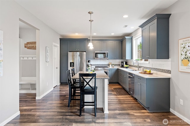1897 Claret Loop NW, Poulsbo, WA 98370 - kitchen featuring appliances with stainless steel finishes, gray cabinets, a center island, decorative backsplash, and recessed lighting
