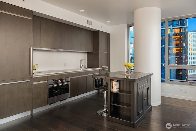 1808 Minor Ave Unit 3005, Seattle, WA 98101 - kitchen featuring oven, open shelves, dark wood-style floors, and dark brown cabinetry