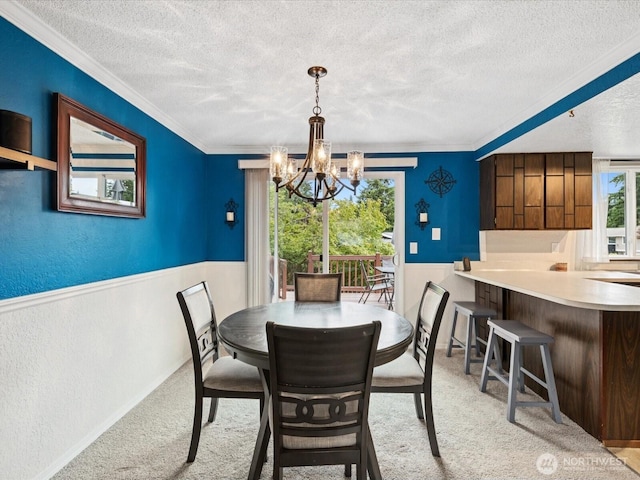2613 172nd Pl SE, Bothell, WA 98012 - carpeted dining space with a textured ceiling, a wainscoted wall, a chandelier, and crown molding