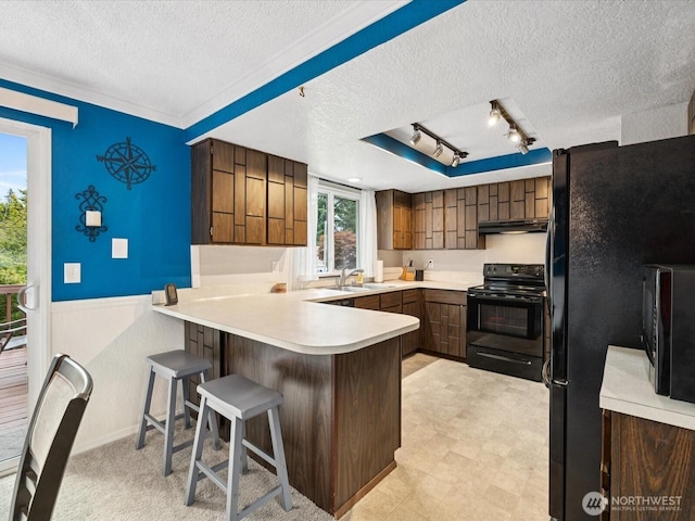 2613 172nd Pl SE, Bothell, WA 98012 - kitchen featuring black appliances, a textured ceiling, a peninsula, track lighting, and wainscoting