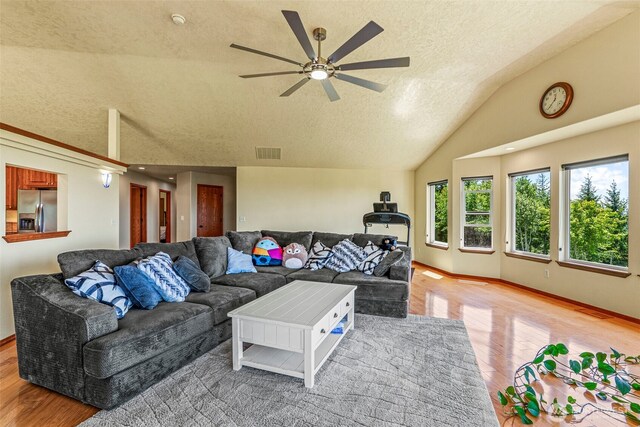 874 W State Route 4, Cathlamet, WA 98612 - living room with light wood finished floors, a textured ceiling, lofted ceiling, and ceiling fan