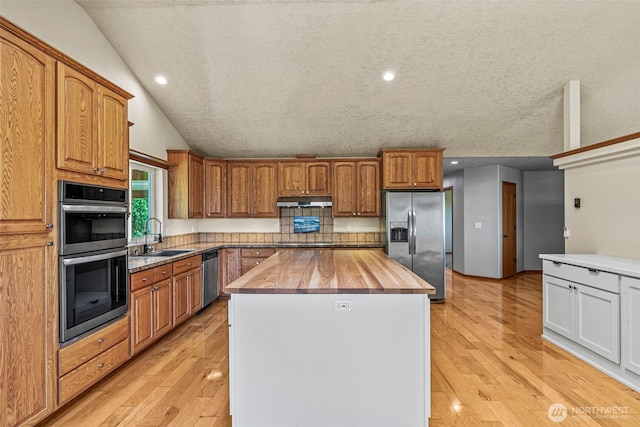 874 W State Route 4, Cathlamet, WA 98612 - kitchen with appliances with stainless steel finishes, butcher block counters, lofted ceiling, a kitchen island, and light wood-style floors