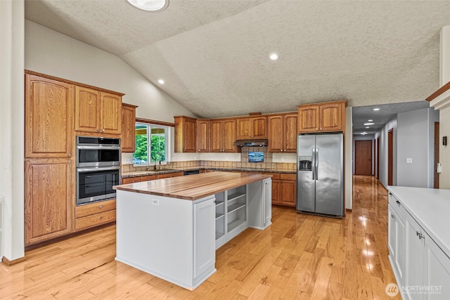 874 W State Route 4, Cathlamet, WA 98612 - kitchen with appliances with stainless steel finishes, butcher block countertops, a kitchen island, light wood finished floors, and brown cabinets