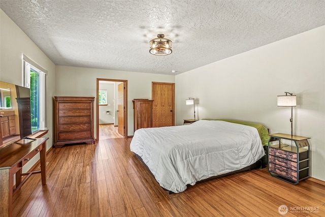 874 W State Route 4, Cathlamet, WA 98612 - bedroom featuring wood-type flooring, a textured ceiling, and ensuite bathroom