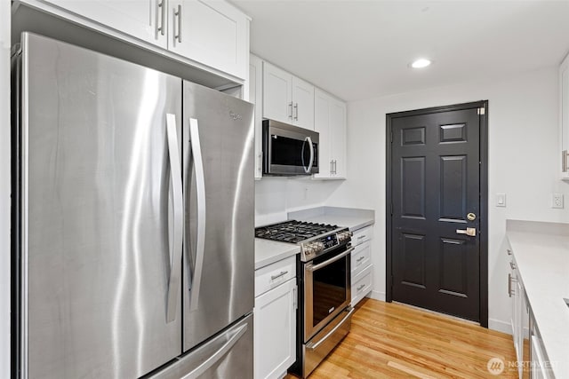12629 SE 169th St, Renton, WA 98058 - kitchen with stainless steel appliances, white cabinets, light wood-type flooring, light countertops, and recessed lighting