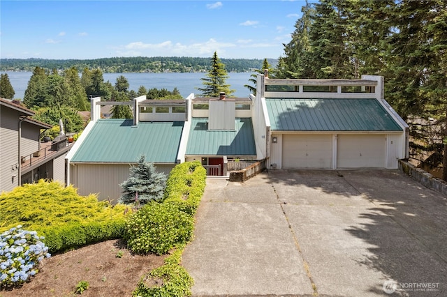 2838 170th Ave SE, Bellevue, WA 98008 - mid-century home with a metal roof, concrete driveway, a water view, and a garage