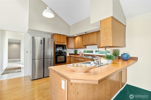 2838 170th Ave SE, Bellevue, WA 98008 - kitchen with black appliances, a peninsula, high vaulted ceiling, light countertops, and brown cabinetry