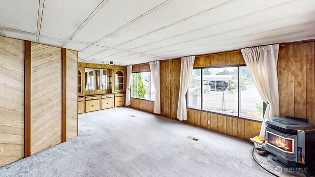 11453 Bayview Edison Rd Unit 25, Mount Vernon, WA 98273 - carpeted spare room with wooden walls and a wood stove