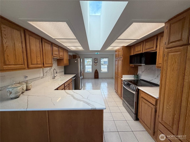 440 W Nelson Rd, Sequim, WA 98382 - kitchen featuring appliances with stainless steel finishes, light tile patterned floors, tasteful backsplash, light stone counters, and brown cabinetry