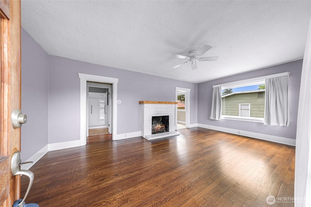 2304 F St, Bellingham, WA 98225 - unfurnished living room with a textured ceiling, ceiling fan, wood finished floors, and a fireplace