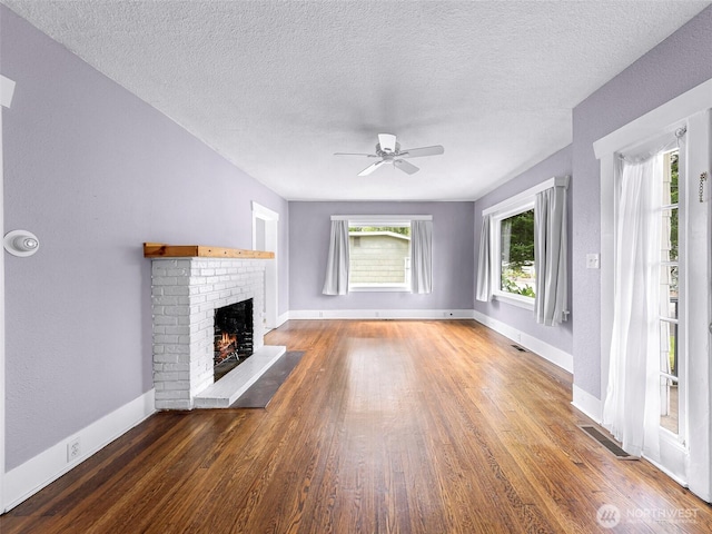 2304 F St, Bellingham, WA 98225 - unfurnished living room featuring wood finished floors, ceiling fan, a fireplace, and a textured ceiling