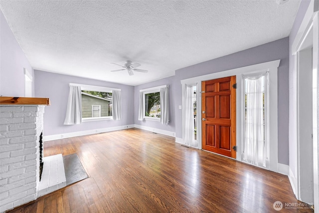2304 F St, Bellingham, WA 98225 - unfurnished living room featuring ceiling fan, wood finished floors, a fireplace, and a textured ceiling