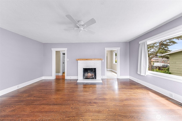 2304 F St, Bellingham, WA 98225 - unfurnished living room featuring a ceiling fan, wood finished floors, a brick fireplace, and a textured ceiling