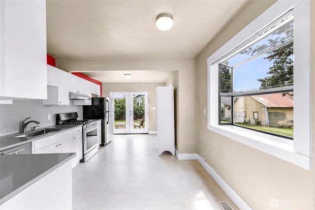 2304 F St, Bellingham, WA 98225 - kitchen with appliances with stainless steel finishes, under cabinet range hood, white cabinetry, and french doors