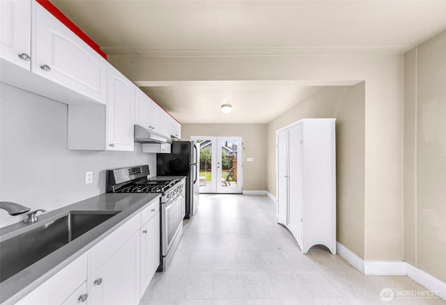 2304 F St, Bellingham, WA 98225 - kitchen featuring appliances with stainless steel finishes, french doors, white cabinets, under cabinet range hood, and dark countertops