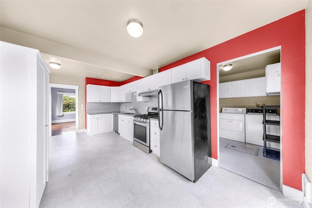2304 F St, Bellingham, WA 98225 - kitchen featuring stainless steel appliances, washer and dryer, white cabinets, and under cabinet range hood