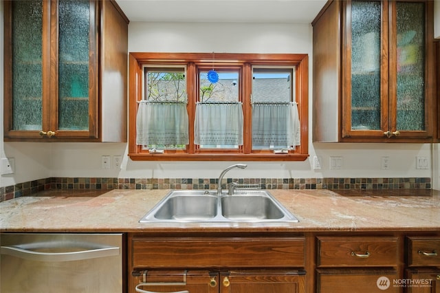 634 University St, Walla Walla, WA 99362 - kitchen with dishwasher, glass insert cabinets, light stone countertops, and brown cabinetry