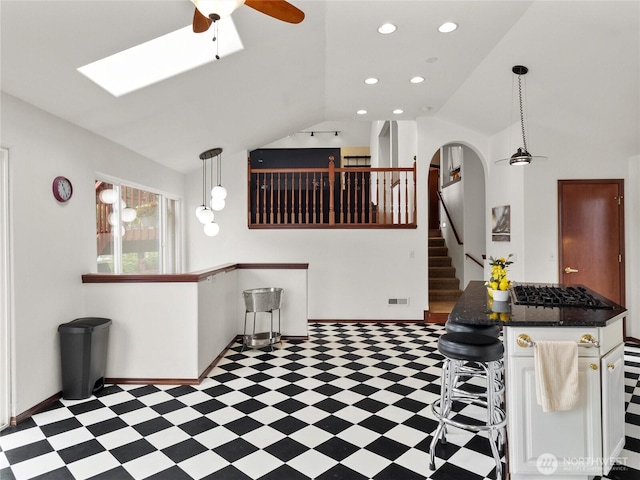 2519 Carpenter Rd, Lacey, WA 98503 - kitchen featuring tile patterned floors, lofted ceiling, a ceiling fan, gas stovetop, and a breakfast bar area