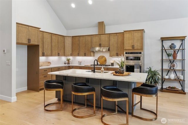 81 Plateau Loop, Cle Elum, WA 98922 - kitchen with stainless steel appliances, under cabinet range hood, brown cabinets, backsplash, and light wood-style floors