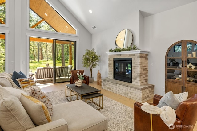 81 Plateau Loop, Cle Elum, WA 98922 - living room with high vaulted ceiling, wood finished floors, a brick fireplace, and plenty of natural light