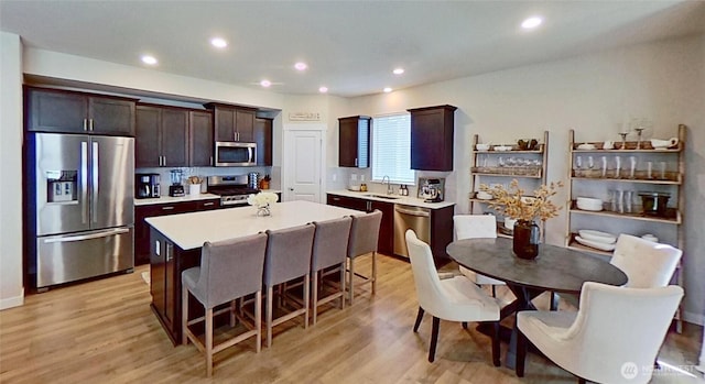 5845 Waverly Rd SW, Port Orchard, WA 98367 - kitchen with stainless steel appliances, a center island, a kitchen breakfast bar, light countertops, and light wood finished floors