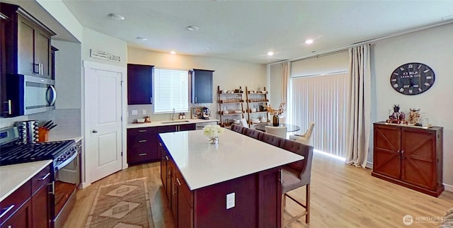 5845 Waverly Rd SW, Port Orchard, WA 98367 - kitchen featuring stainless steel appliances, a breakfast bar, light wood-style floors, a kitchen island, and light countertops