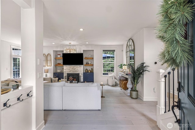 2166 NE Morgan Ln, Issaquah, WA 98029 - living room featuring a warm lit fireplace, light wood finished floors, recessed lighting, and a chandelier