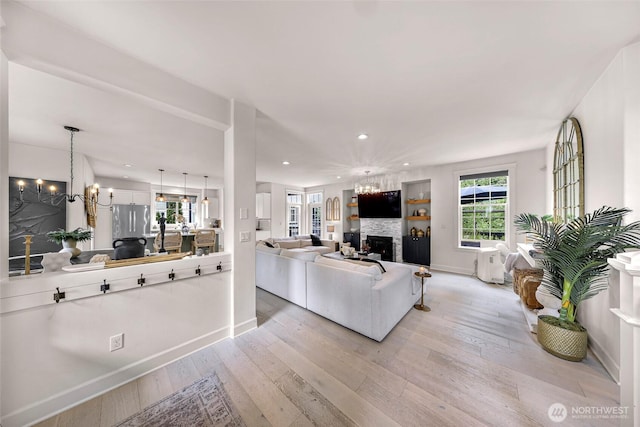 2166 NE Morgan Ln, Issaquah, WA 98029 - living area featuring light wood finished floors, a chandelier, a fireplace, and recessed lighting