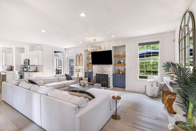 2166 NE Morgan Ln, Issaquah, WA 98029 - living area featuring recessed lighting, light wood-type flooring, a chandelier, and a glass covered fireplace