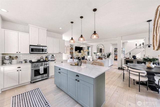 2166 NE Morgan Ln, Issaquah, WA 98029 - kitchen with appliances with stainless steel finishes, a center island, white cabinets, tasteful backsplash, and recessed lighting