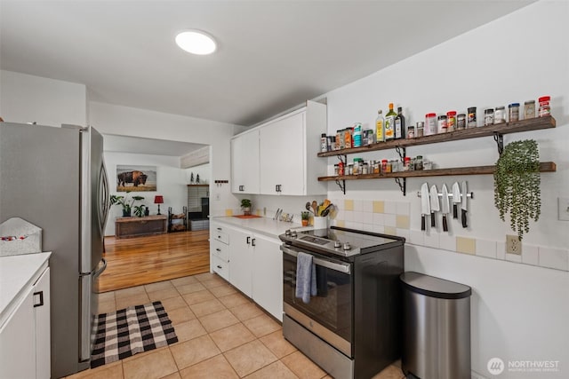 14985 Chumstick, Leavenworth, WA 98826 - kitchen with appliances with stainless steel finishes, light countertops, open shelves, white cabinetry, and light tile patterned floors