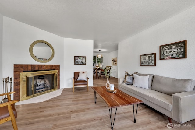 7040 SE Truman St, Port Orchard, WA 98366 - living area with light wood-style floors and a tile fireplace