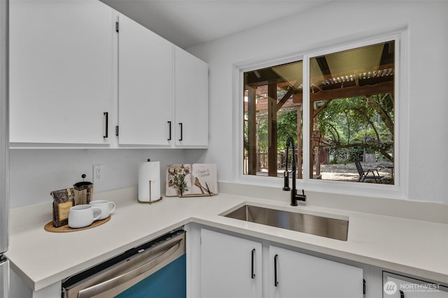 7040 SE Truman St, Port Orchard, WA 98366 - kitchen with stainless steel dishwasher, light countertops, white cabinetry, and dishwashing machine