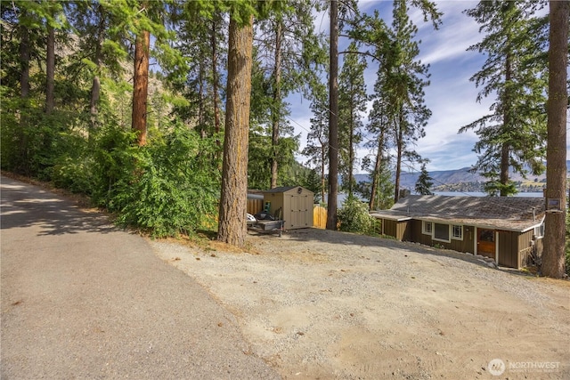 9368 S Lakeshore Rd, Chelan, WA 98816 - view of front of home featuring a storage unit, a mountain view, and dirt driveway