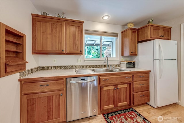 141 Leslie Ln, Sequim, WA 98382 - kitchen with stainless steel dishwasher, freestanding refrigerator, light wood-style floors, brown cabinetry, and open shelves