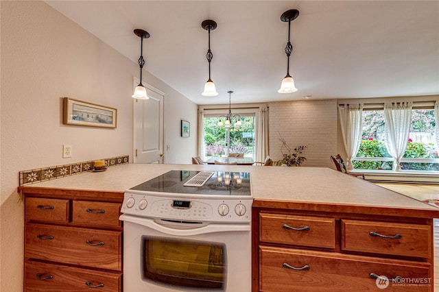 141 Leslie Ln, Sequim, WA 98382 - kitchen featuring white range with electric stovetop, brown cabinetry, plenty of natural light, and light countertops