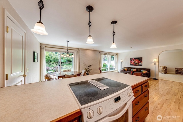 141 Leslie Ln, Sequim, WA 98382 - kitchen with white range with electric stovetop, light wood-type flooring, light countertops, and decorative light fixtures