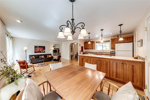 141 Leslie Ln, Sequim, WA 98382 - dining room featuring arched walkways, light wood finished floors, a chandelier, and recessed lighting