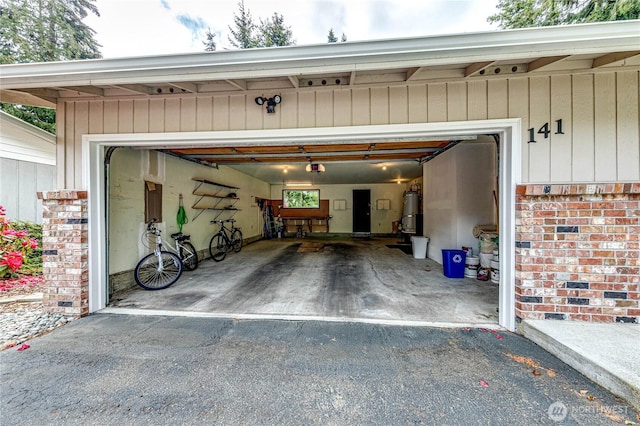 141 Leslie Ln, Sequim, WA 98382 - garage with driveway, a garage door opener, and secured water heater