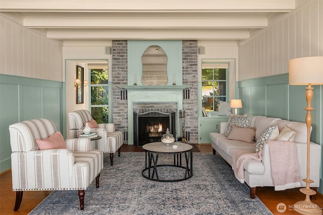 14504 Glen Acres Rd, Vashon, WA 98070 - living room with a decorative wall, wood finished floors, beamed ceiling, and a fireplace