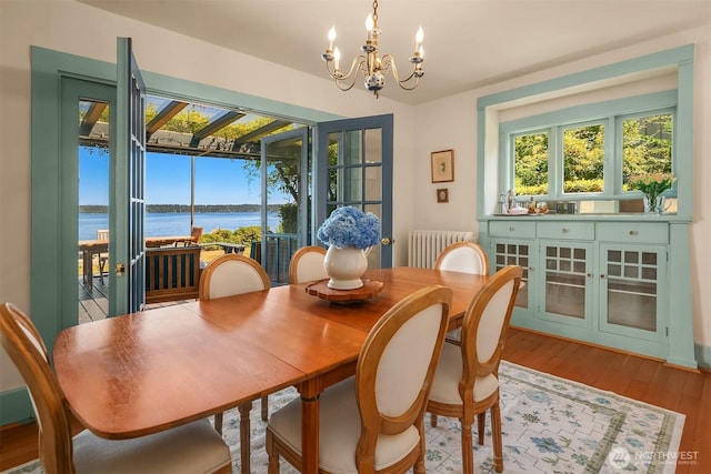 14504 Glen Acres Rd, Vashon, WA 98070 - dining space with radiator, a chandelier, wood finished floors, and plenty of natural light