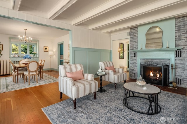 14504 Glen Acres Rd, Vashon, WA 98070 - living room featuring radiator, a chandelier, hardwood / wood-style floors, beam ceiling, and a fireplace