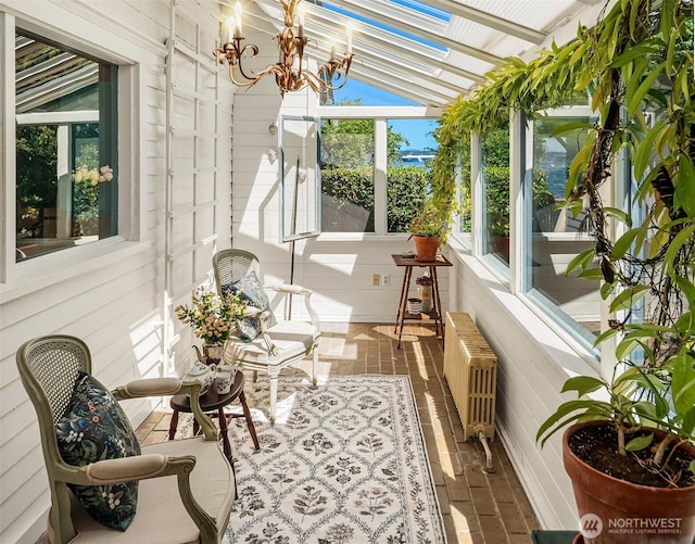 14504 Glen Acres Rd, Vashon, WA 98070 - sunroom featuring radiator heating unit, a chandelier, vaulted ceiling, and brick flooring