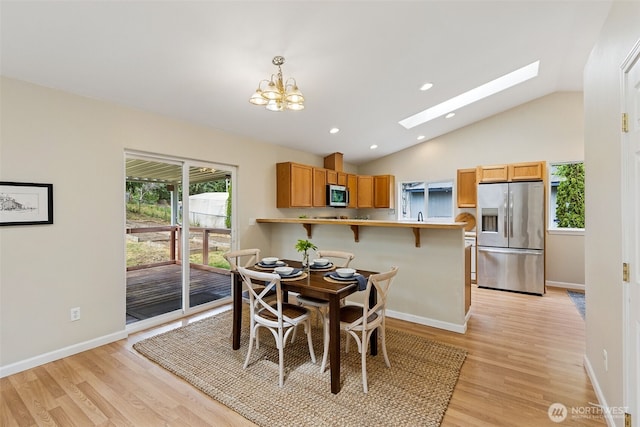8537 Thuja Ave SE, Yelm, WA 98597 - dining area with light wood finished floors, a skylight, vaulted ceiling, a chandelier, and recessed lighting