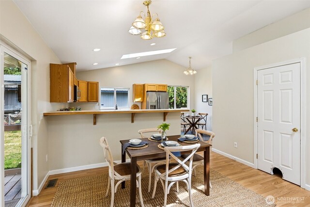 8537 Thuja Ave SE, Yelm, WA 98597 - dining room featuring a chandelier, a skylight, healthy amount of natural light, light wood-style floors, and lofted ceiling