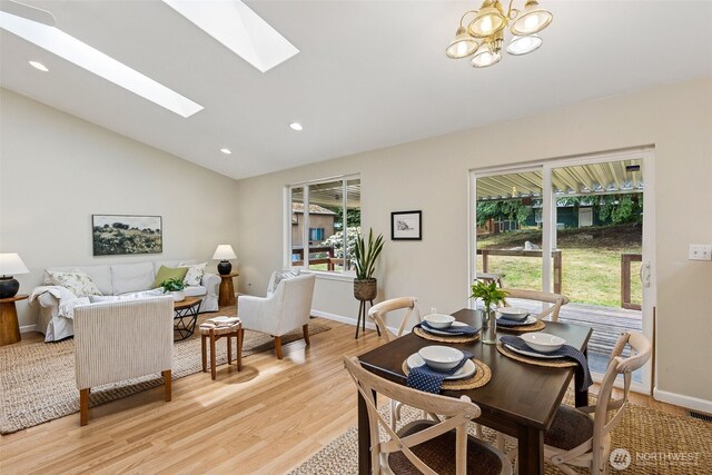 8537 Thuja Ave SE, Yelm, WA 98597 - dining space with vaulted ceiling, a skylight, light wood finished floors, recessed lighting, and a chandelier