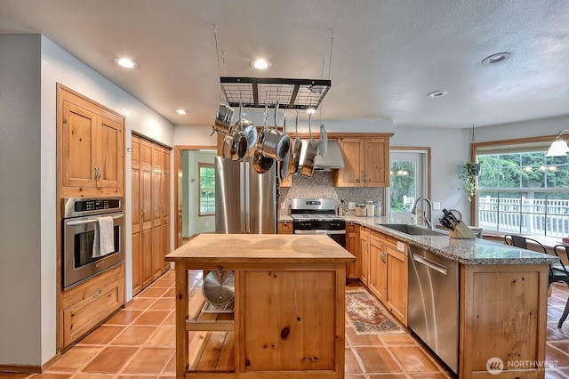 5679 W 31st Crst, Ferndale, WA 98248 - kitchen with appliances with stainless steel finishes, butcher block counters, exhaust hood, a peninsula, and backsplash
