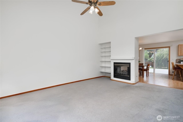 3401 F Ave, Anacortes, WA 98221 - unfurnished living room with light colored carpet, a towering ceiling, a ceiling fan, and a multi sided fireplace