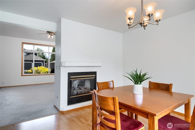 3401 F Ave, Anacortes, WA 98221 - dining room with a glass covered fireplace, a chandelier, a ceiling fan, and light wood-style floors